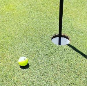 a yellow tennis ball on a putting green at La Bella Vita in Cagliari