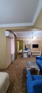 Habitación de hotel con cama y sala de estar. en Hotel Genatsvale en Batumi