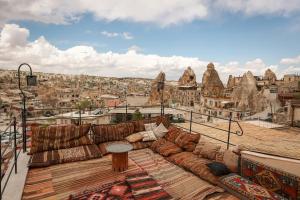 a couch sitting on top of a balcony with a view at Mia Cappadocia Cave Hotel in Goreme
