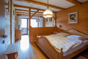 Schlafzimmer mit einem Bett und einem Kronleuchter in der Unterkunft Waldhauser Hof in Schönau am Königssee