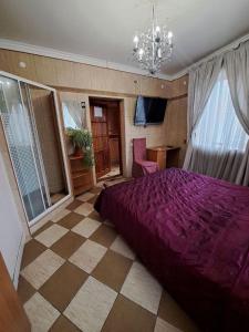 sypialnia z dużym fioletowym łóżkiem i żyrandolem w obiekcie Zatyshok w Czerniowcach