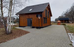 a small wooden building with a basketball hoop at Pauza Drzewoszewo - Dom nad jeziorem in Drzewoszewo
