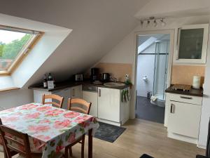 eine Küche mit einem Tisch und Stühlen sowie ein Badezimmer in der Unterkunft Goldener Anker, verschiedene gemütliche Ferienwohnungen in Rheinsberg
