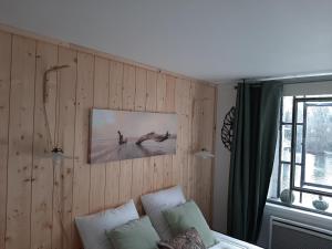 Habitación con paredes de madera y una foto en la pared. en Dans moulin au bord de l'eau, Appartement chaleureux en Saint-Pryvé-Saint-Mesmin
