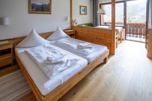 ein Schlafzimmer mit einem großen Bett mit weißer Bettwäsche in der Unterkunft Waldhauser Hof in Schönau am Königssee