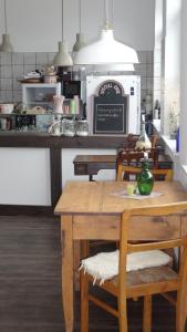 uma cozinha com uma mesa e cadeiras numa cozinha em Pension Kchischowka em Vetschau