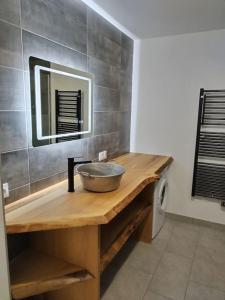 a bathroom with a sink and a mirror on a counter at Maison tout confort in La Voivre