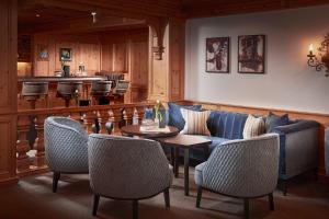 a living room with a couch and a table and chairs at Hotel Auenhof in Lech am Arlberg