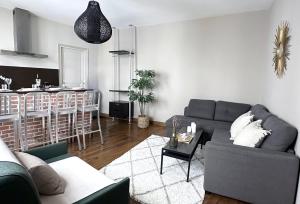 un soggiorno con divano grigio e una cucina di 1624 - Studio Le Marais in Paris Olympic Games 2024 a Parigi