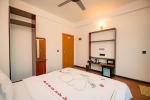 ein Schlafzimmer mit einem Bett mit einer weißen Decke in der Unterkunft Gaafaru View Inn in Gaafaru