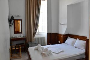 Leonidas Hotel في غيتيو: غرفة نوم عليها سرير وفوط