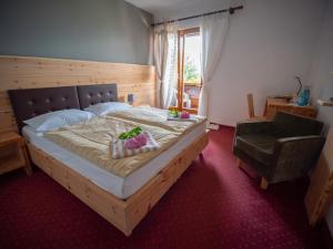 a bedroom with a large bed and a chair at Hotel Buchholz in Salorno sulla Strada del Vino