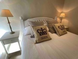 a bedroom with a white bed with pillows on it at Beautiful cottage in country village near Longleat in Maiden Bradley