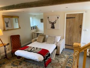 ein Schlafzimmer mit einem Bett und einem Stuhl darin in der Unterkunft Beautiful cottage in country village near Longleat in Maiden Bradley