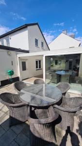 a patio with a table and chairs and a house at Roos Guesthouse Holiday Appartements in Schin op Geul