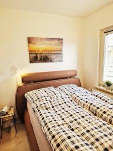 ein Schlafzimmer mit einem Bett mit einer karierten Decke darauf in der Unterkunft Ferienhaus Kranichnest in Barth