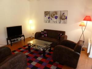 a living room with two couches and a tv at Maison Campagne Petite Mère in Cabriès