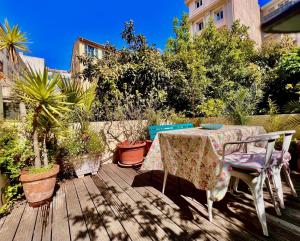 a table and chairs on a deck with plants at ApartHotel Riviera - Grimaldi Coeur de Ville - Large Studio AC with bigger South Terrace - Hyper Centre - TERRASSE ESPRIT in Nice