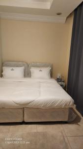 a bedroom with a bed with white sheets and pillows at Pharaohs Inn Deira Hostel in Dubai
