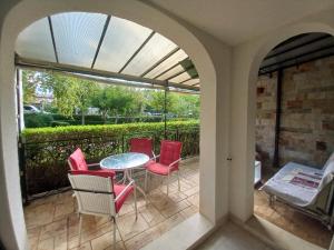 a patio with red chairs and a table on a patio at Luxury Apartments Artur in Sveti Vlas