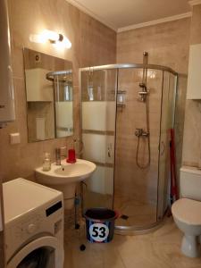 a bathroom with a shower and a sink and a washing machine at Luxury Apartments Artur in Sveti Vlas