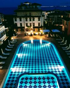 a swimming pool lit up at night at Luxury Apartments Artur in Sveti Vlas