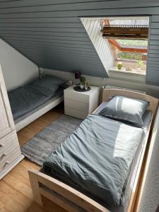 1 dormitorio en el ático con cama y ventana en Ferienwohnung Freitag en Gammendorf