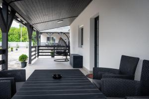 eine Terrasse mit Stühlen und einem Tisch auf der Veranda in der Unterkunft Napsugár & Virág Apartman 4 csillagos in Tiszafüred