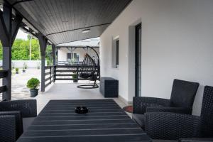 a patio with chairs and a table on a porch at Napsugár & Virág Apartman 4 csillagos in Tiszafüred