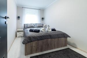 Un dormitorio con una cama grande y una ventana en Napsugár & Virág Apartman 4 csillagos en Tiszafüred