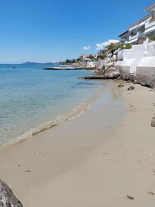 a beach next to the ocean with buildings at PANSION ALEXANDROS BY THE SEA in Nea Skioni
