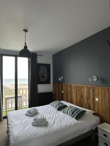 a bedroom with a large bed with a view of the ocean at Papagayo in Saint-Aubin-sur-Mer