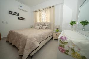 - une chambre blanche avec un lit et une fenêtre dans l'établissement Luxury Apt Ibr Naco 1br Poolgym, à Saint-Domingue