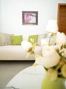 een woonkamer met een bank en bloemen in een vaas bij Luxury Apt Ibr Naco 1br Poolgym in Santo Domingo