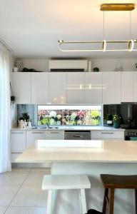 een keuken met witte kasten en een wit aanrecht bij Serenity Cove luxe retreat in Maroochydore