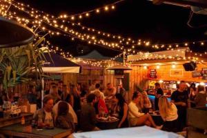 een groep mensen die aan een bar met lichten zitten bij Serenity Cove luxe retreat in Maroochydore