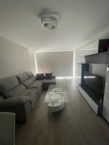 ein Wohnzimmer mit einem Sofa und einem Tisch in der Unterkunft Apartamento Cervantino in Alcalá de Henares