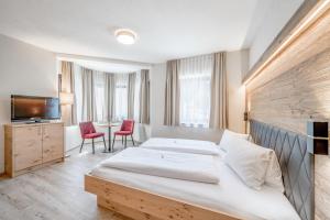 a hotel room with two beds and a television at Gasthof Schroll in Kirchbichl