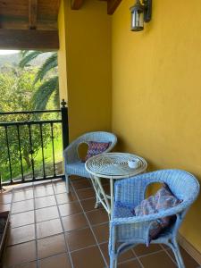 a patio with two chairs and a table and a balcony at La Canal in Ubiarco