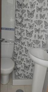 uma casa de banho com um WC e uma cortina de chuveiro de borboletas. em Vivienda Balcón al amanecer em Santa Cruz de la Palma