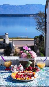 Una mesa con un plato de comida encima con vista al agua. en Apartment Selman, en Nin