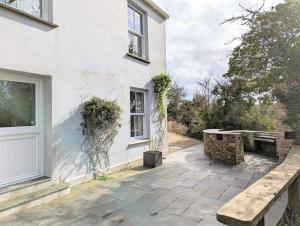 a patio with a bench next to a building at Romantic Secluded Hideaway Cottage in Cornwall in Truro