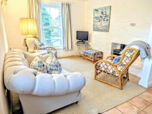 a living room with a white couch and chairs at Romantic Secluded Hideaway Cottage in Cornwall in Truro