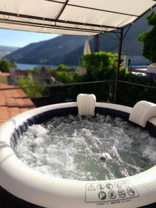 uma banheira de hidromassagem com água e um guarda-sol em Casa Nunes 2 em Pinhão