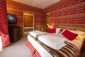 a bedroom with a bed with red and gold wallpaper at Hotel Bucaneve in Breuil-Cervinia