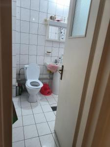 a bathroom with a toilet and a white tiled floor at Italian Villa in Turbaţi