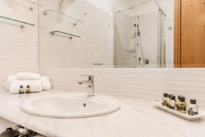 a white bathroom with a sink and a shower at Frezza's Holidays in Rome +33 photos