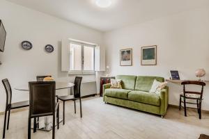 a living room with a green couch and a table at Frezza's Holidays in Rome