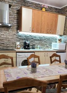 a kitchen with a table and a stove and a microwave at Kara Apartman in Odorheiu Secuiesc