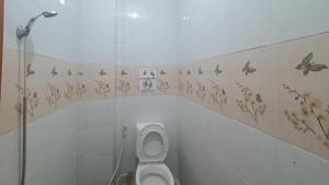 bagno con servizi igienici e farfalle sul muro di Reddoorz @ Homestay Gayatri a Malang